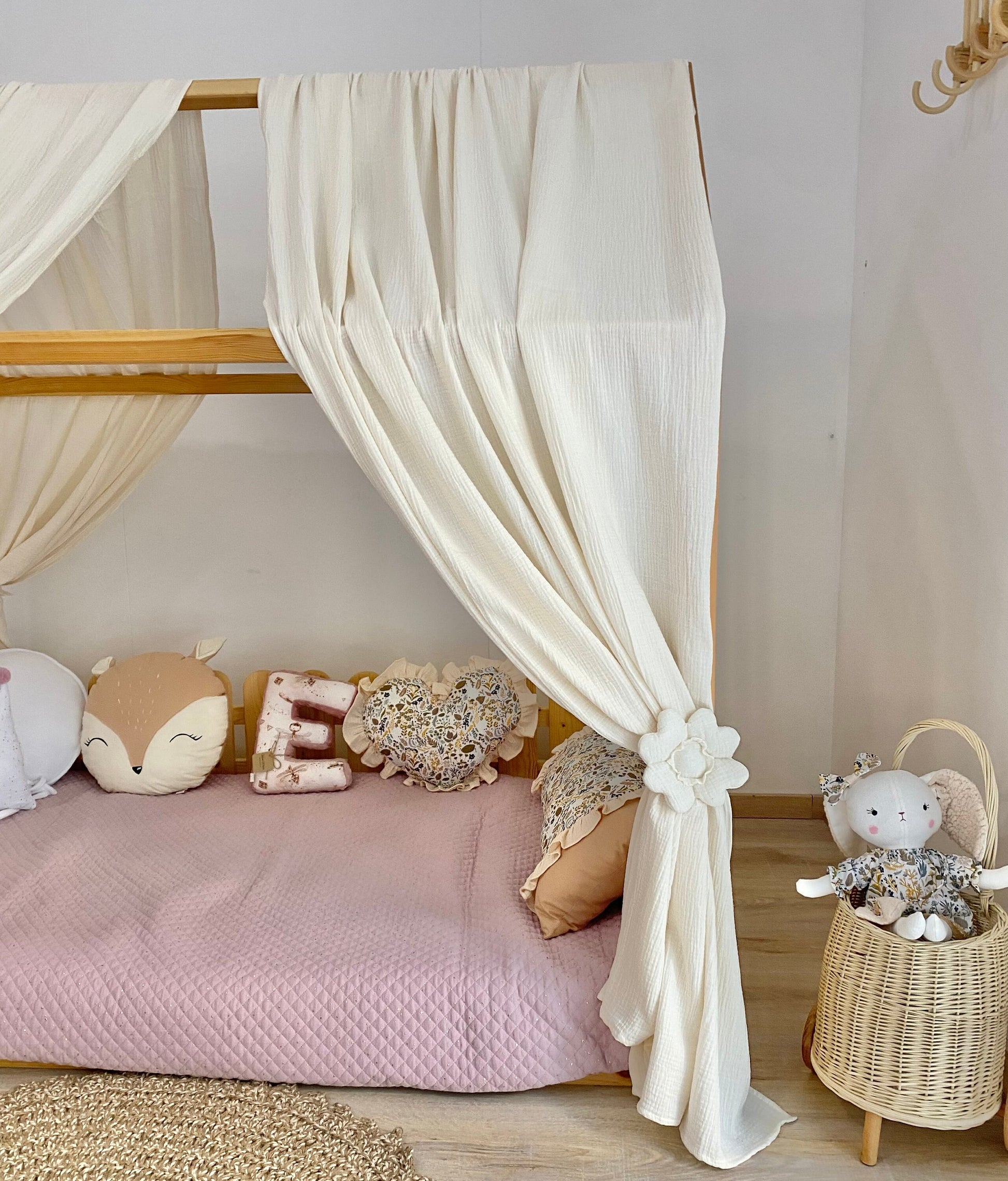 Cream canopy draped over Montessori floor bed
