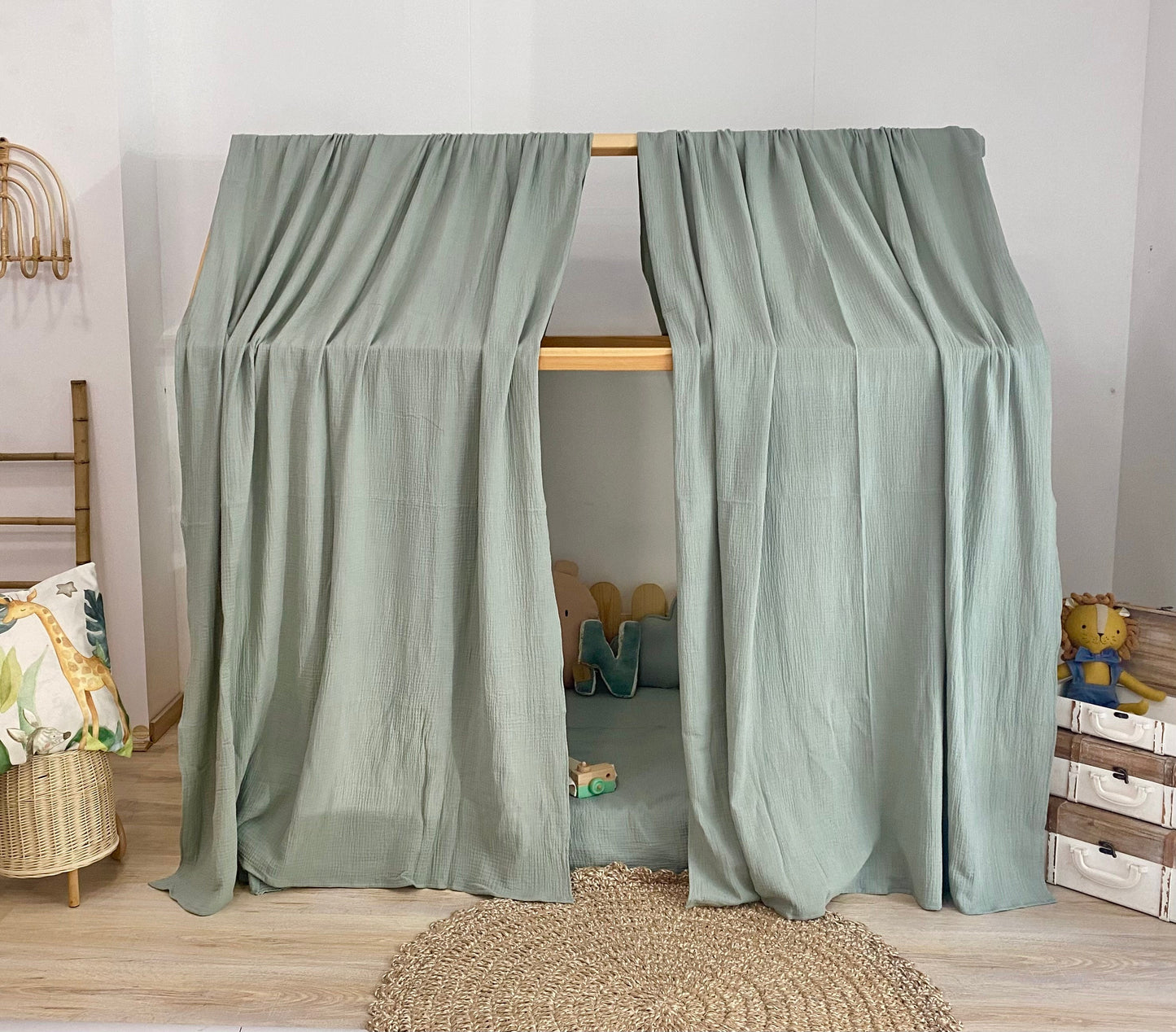 Sage green canopy over floor bed in kids room
