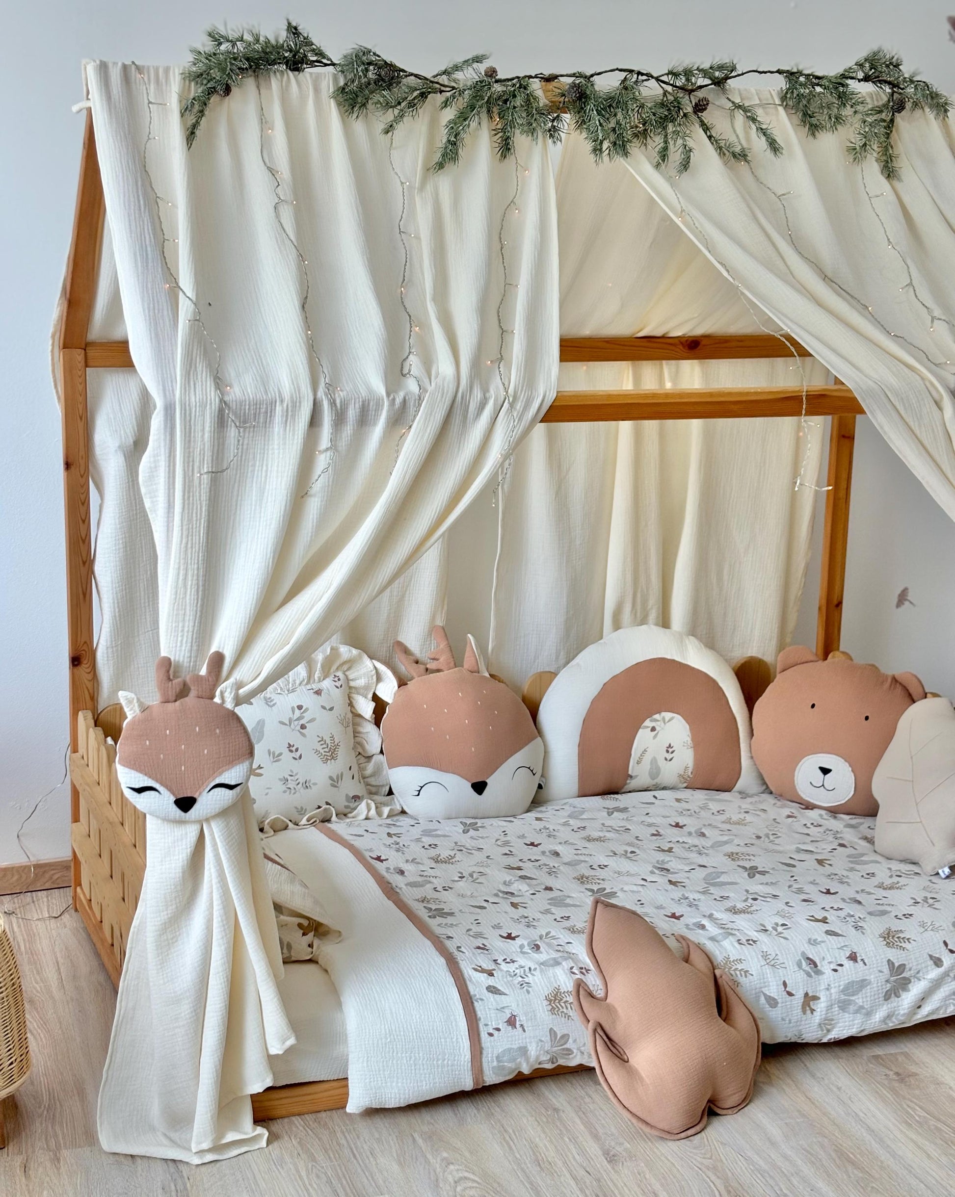 Calming kids bedroom with natural wood furniture, cream canopy and beige rug.
