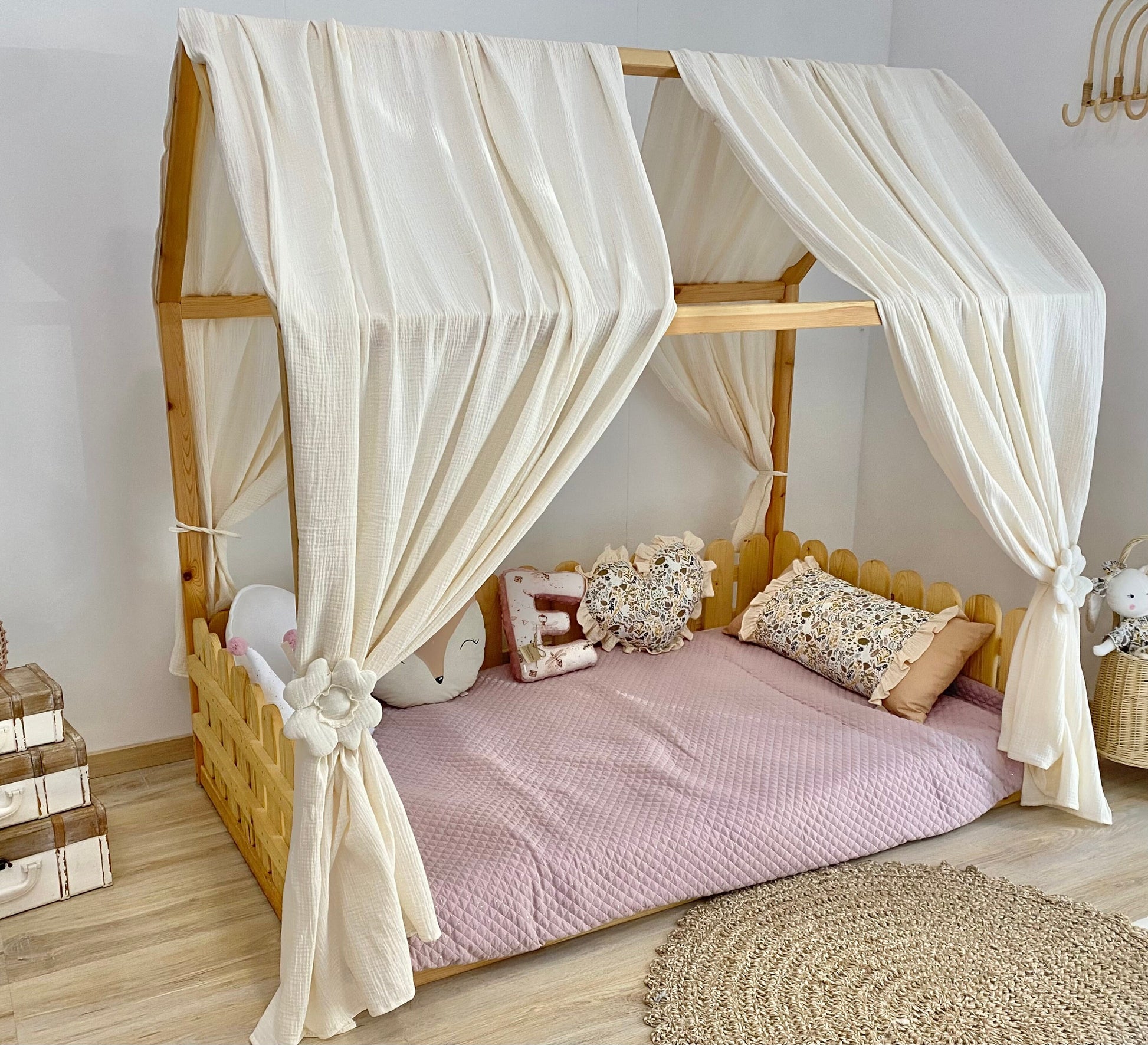 Cream canopy draped over Montessori floor bed