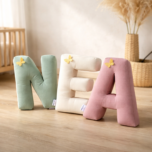 Personalized alphabet letter pillows spelling name in soft neutral nursery setting
