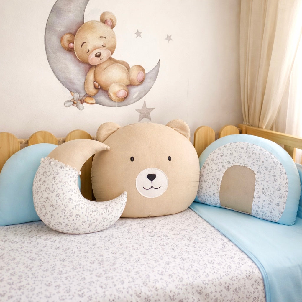 Children's room with teddy bear-themed pillows and a moon-shaped cushion.