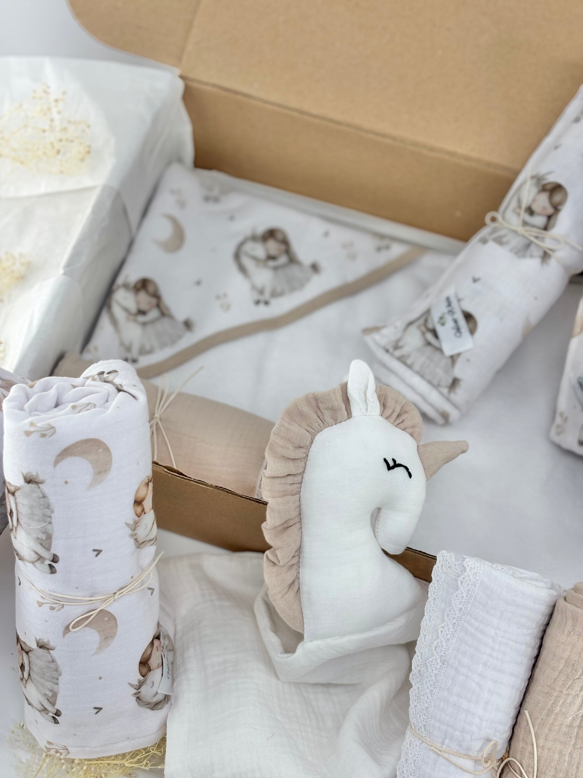 Baby gift set with swaddle blankets, rattle, and other items in a box.