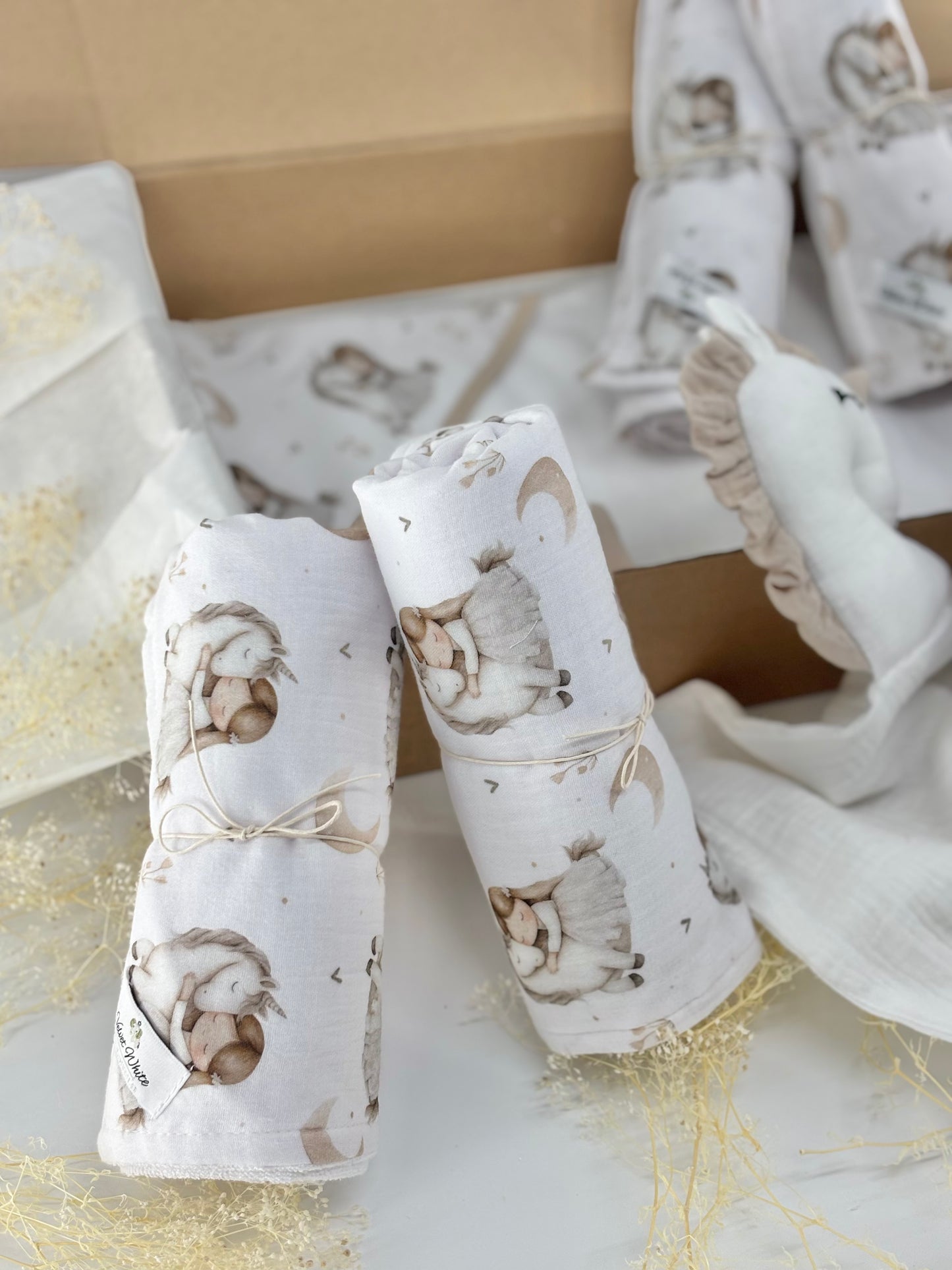 Two baby swaddle blankets with animal prints on a light background