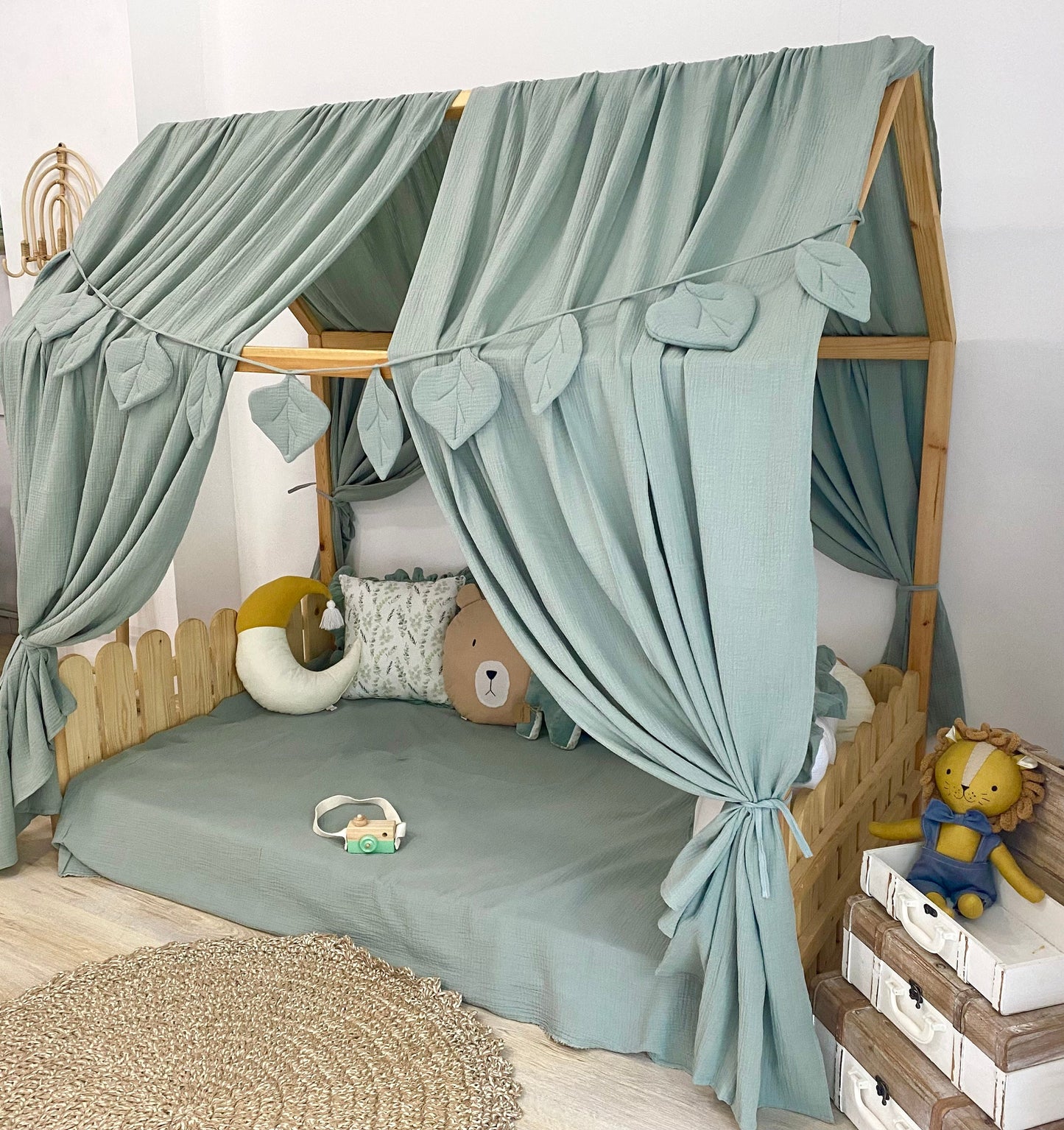 Sage green canopy over floor bed in kids room